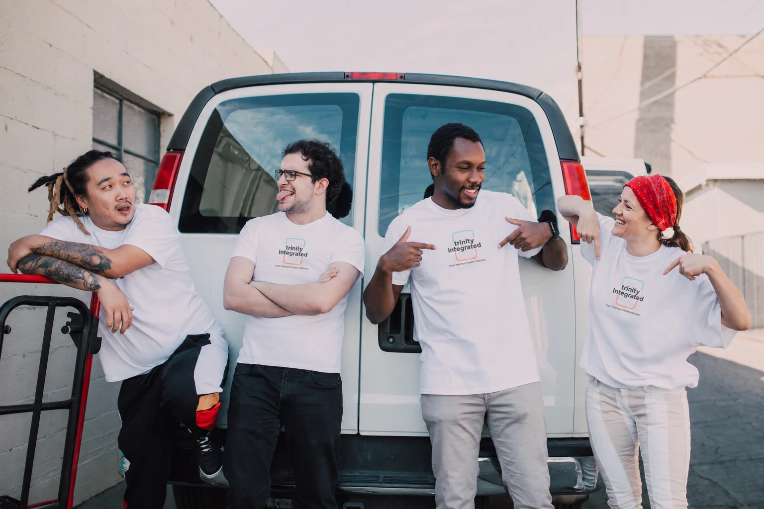 Smiling community volunteers beside a van