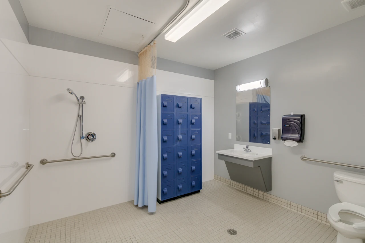 Bathroom with a shower, bench, and grab bars