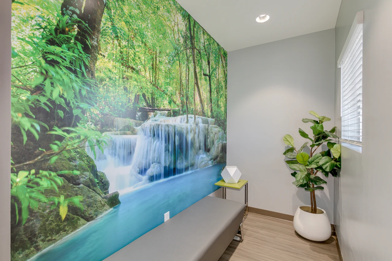A seating nook beside a waterfall mural